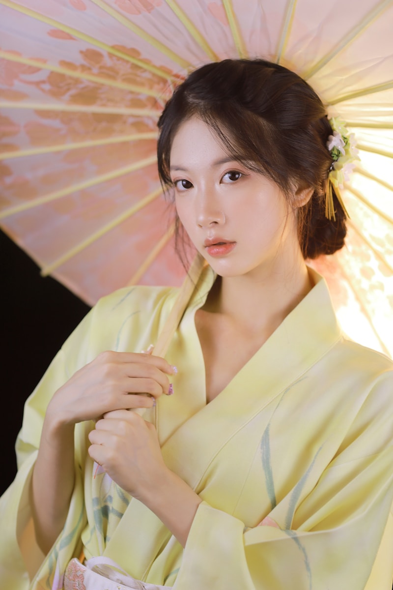 woman in white blazer holding pink umbrella